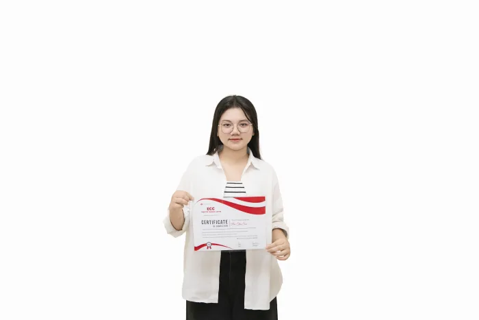 An ECC graduate holding their course completion certificate